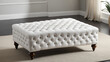 © Lauren - Elegant white tufted ottoman with wooden legs, perfect for enhancing modern or traditional interior decor.