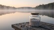 © GMeta - Colorful sand filled jar with seashells on wooden pier at misty lake sunrise