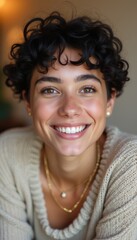 Canvas Print - A joyful young woman with short, curly hair beams with happiness, showcasing her bright smile and sparkling eyes. Dressed in a cozy sweater, she exudes warmth and approachability, inviting viewers to