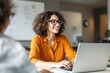 © PlanetOfVectors - Woman in orange shirt with glasses smiling while working on laptop, modern office background, concept of productivity and workplace positivity. Ai generative