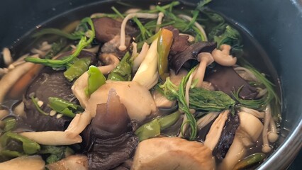 Wall Mural - Thai mushroom soup in a black bowl