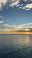 Wall Mural - Orange sunset over sea on the beach, vertical video.