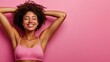 © Pannee - Joyful woman with curly hair posing against a pink background