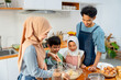 © narong - Muslim mother show example to mix flour in the bowl for her child to make the bakery in kitchen of their house.
