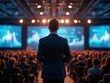© Mikhail - Business leader addresses large audience at conference with data visuals in the background