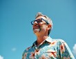 © umut hasanoglu - A man smiles contentedly, gazing upwards at a bright blue sky. He's wearing a floral shirt and glasses, enjoying a sunny day.