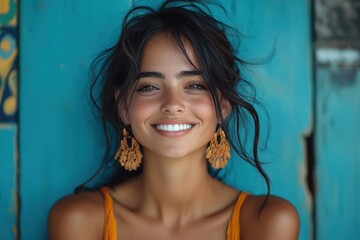 Wall Mural - Smiling woman with natural beauty poses against a vibrant blue wall in a sunny outdoor setting