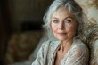 © Roman Ribaliov - Elegant older woman with gray hair and radiant smile sits comfortably in a cozy living room during soft afternoon light