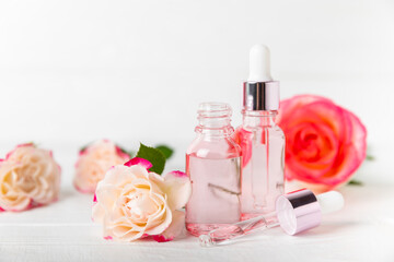 Wall Mural - Rose essential oil on a textured background.Roses and a bottle of rose perfumed water.Aromatherapy treatment. Beauty concept. Spa procedure.Natural organic oil.Anti-stress,detox relax.Place for text