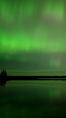 Wall Mural - panning to the right of a time lapse of northern lights reflecting in a calm lake