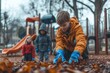 © Galina - Children enjoy a cool autumn day gathering leaves in a playground while dressed in warm clothing