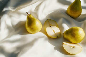 Poster - Three whole pears and two pear halves on white fabric in sunlight.