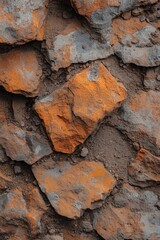 Aufkleber - Close-up of rough, textured orange and grey stones set in earthy soil.