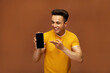 © Royaltyfreecliick - A young Indian model is pointing at the phone's screen.