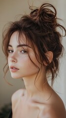 Wall Mural - A messy bun with loose curls and subtle highlights, styled for a casual yet elegant vibe.