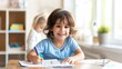 © Vilaysack - A cheerful child enjoys drawing at a table, showcasing creativity and happiness in a bright, inviting room.