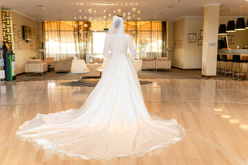 Beautiful young bride in a long dress in a beautiful hotel suite. Wedding photography