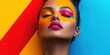 © Olexandr Tytarchuk - A model shows off an artistic makeup style with bright colors like orange, pink, and blue, highlighting her features in a striking studio environment