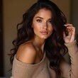 © Drowfear - Una mujer con cabello ondulado y suelto, luciendo un suéter beige de un solo hombro, en un ambiente cálido y acogedor