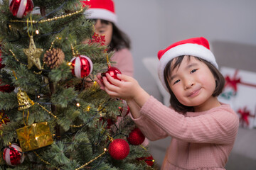 Wall Mural - 女の子たちが一緒に楽しむクリスマスツリーのデコレーション