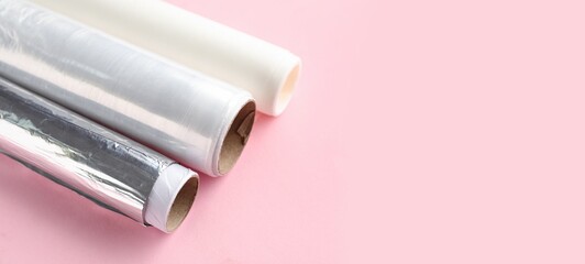 Canvas Print - Rolls of aluminium foil, baking paper and food film on pink background with space for text