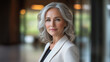 © Tahsin - Professional woman with silver hair poses confidently in modern indoor space