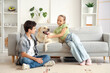 © Pixel-Shot - Happy sister and brother with cute Labrador dog sitting on sofa at home