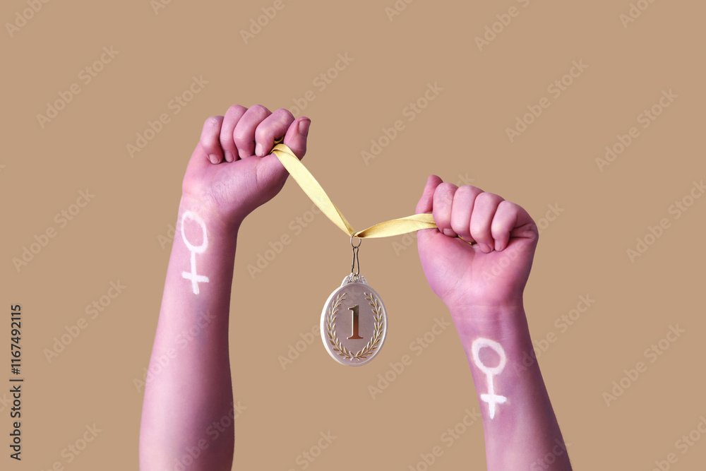 Woman with painted hands holding first place medal on brown background. Feminism concept