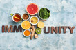 © Pixel-Shot - Composition with word IMMUNITY made of wooden letters, different healthy food and cup of tea on color grunge background