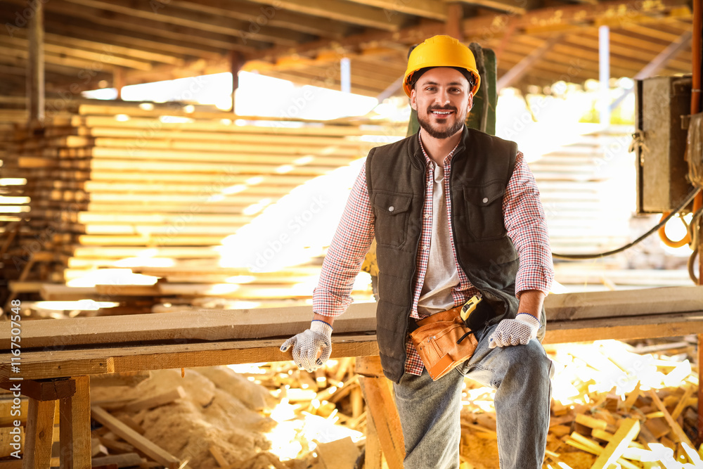 Portrait of young carpenter in hardhat at sawmill