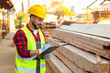 © Pixel-Shot - Young carpenter in reflective vest with clipboard working at sawmill