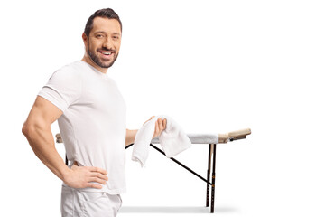 Massage therapist holding a towel in front of a massage table