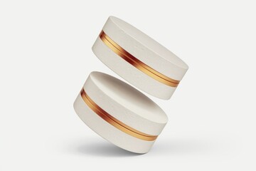 Aufkleber - Two off-white cylindrical objects with gold accents, seemingly floating.