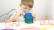 © I - boy playing with a 3D pen at the table
