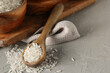 © Pixel-Shot - Uncooked white rice grains in wooden spoon and bowl on rustic gray background, healthy eating and cooking ingredient