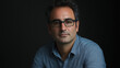 © VicPhoto - Retrato de hombre con gafas y camisa azul sobre fondo oscuro