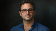 © VicPhoto - Retrato de hombre con gafas y camisa azul sobre fondo oscuro