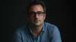 © VicPhoto - Retrato de hombre con gafas y camisa azul sobre fondo oscuro