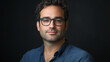 © VicPhoto - Retrato de hombre con gafas y camisa azul sobre fondo oscuro