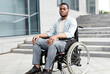 © Prostock-studio - Accessible facilities for disabled people. Portrait of unhappy black impaired man in wheelchair next to siatrs without ramp, feeling stressed, having difficulty in entering building, free space
