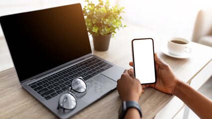 Poster - Cropped view of young black lady with smartphone and laptop shopping online, using new mobile app and website to order goods on web from home during coronavirus lockdown, mockup