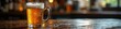 © dadtophoto - Condensation-covered glass of beer sits on dark wood table , tavern, head, pint