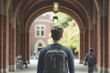 © jambulart - Student walks through brick archway, backpack.
