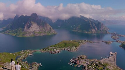 Wall Mural - discover the stunning beauty of norway as two figures admire a sweeping vista of rocky peaks and a t