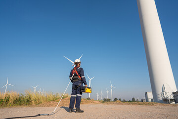 Wall Mural - engineer wearing uniform inspection and survey work in wind turbine farms rotation to generate elect