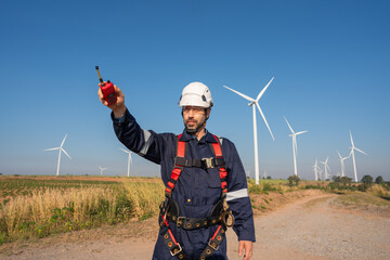 Wall Mural - engineer wearing uniform inspection and survey work in wind turbine farms rotation to generate elect