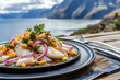 © Juri - A beautifully plated ceviche from Peru, featuring fresh fish marinated in citrus juices, with red onions, cilantro, and corn, served on a rustic wooden table by the sea