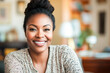 © Victor - Smiling black woman in a cozy home interior, radiating warmth and confidence, symbolizing positivity and relaxation.