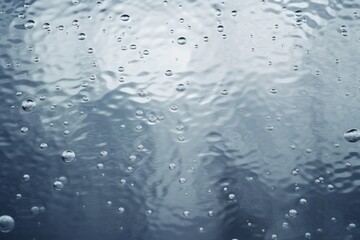 Aufkleber - raindrops create ripples on a calm surface reflecting soft light in a tranquil setting