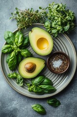 Wall Mural - Fresh avocado halves with basil and sea salt arranged on a decorative plate